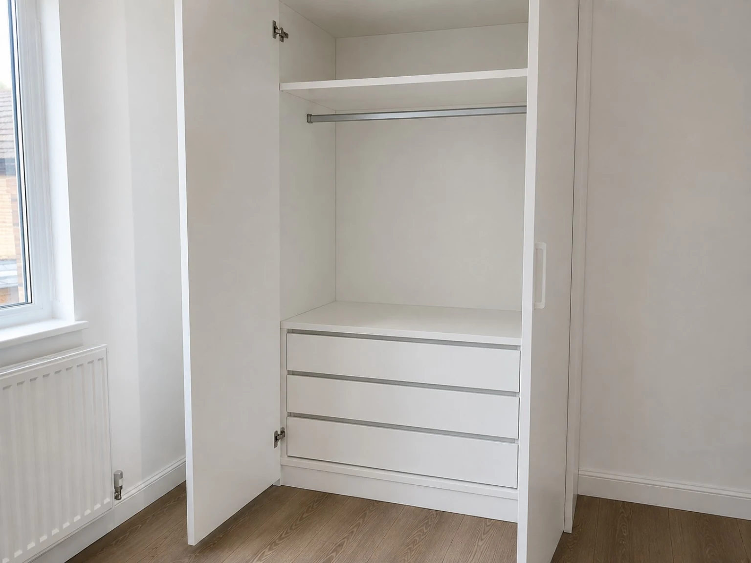 Built-in white wardrobe interior with shelf, hanging rail and three drawers assembled in Dublin